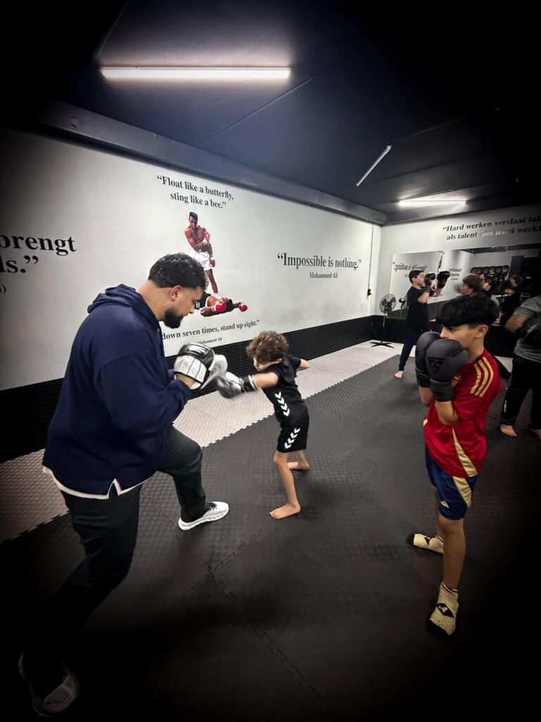 Coach begeleidt een groep tijdens een kickbokstraining bij TPA